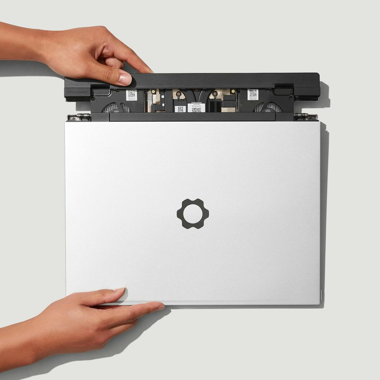 Framework Laptop 16 with its graphics module partially removed, showing the swappable GPU bay